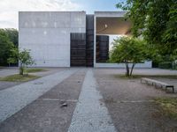 an empty walkway between a brick plaza and an open building on the ground at dusk