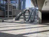 an escalator near the large, empty building in the city skyline with many windows