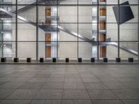 a very big square with some stairs and windows at night time with a fire hydrant sitting in front of it