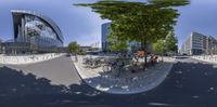 a fisheye view of a bicycle parking lot with bicycles and cars in the background