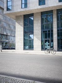 there is a woman standing in the street in front of a building that has glass on it