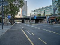 a city street that has a bridge over the road at sunset on a clear day