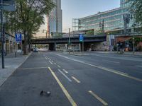 a city street that has a bridge over the road at sunset on a clear day