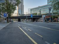 a city street that has a bridge over the road at sunset on a clear day