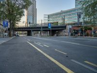 a city street that has a bridge over the road at sunset on a clear day