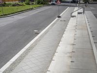 a paved road in the middle of the day with cars parked on both sides of the street