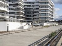 this is a road lined with a building that has many balconies on top