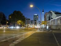 a street with a few street lights and an office building in the background at night
