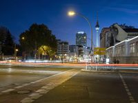 a street with a few street lights and an office building in the background at night