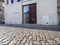 a cobblestone street is near a large old building on a sunny day in the country