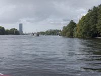 two life buoys on a river with buildings in the background in summer time with heavy clouds