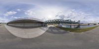 this is a fish eye view of the street bridge in a park with a river