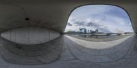 a person is riding a skateboard in a concrete circular structure, looking out through it