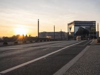 a train sitting on the side of a bridge next to buildings under the setting sun