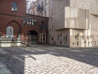 a brick walkway through two red brick buildings with steps leading to it and the door