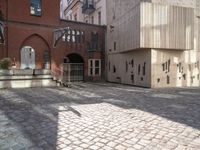 a brick walkway through two red brick buildings with steps leading to it and the door