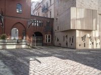 a brick walkway through two red brick buildings with steps leading to it and the door