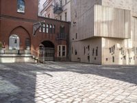 a brick walkway through two red brick buildings with steps leading to it and the door