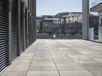 an empty sidewalk between some buildings and some stairs in the background? of the urban area