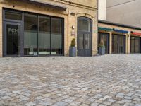 the pavement is lined with stone blocks to make up a sidewalk, sidewalk with sidewalk level windows