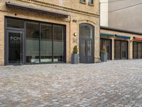 the pavement is lined with stone blocks to make up a sidewalk, sidewalk with sidewalk level windows