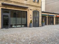 the pavement is lined with stone blocks to make up a sidewalk, sidewalk with sidewalk level windows