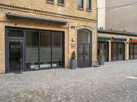 the pavement is lined with stone blocks to make up a sidewalk, sidewalk with sidewalk level windows