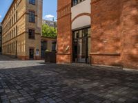 a sidewalk with chairs next to the brick building on the side, some have stairs and some buildings in the background