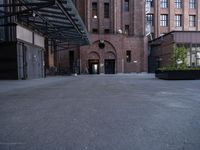 a walkway leads to a building and a gated entrance on both sides of the road