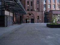 a walkway leads to a building and a gated entrance on both sides of the road