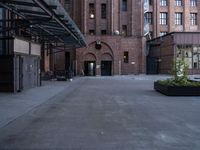 a walkway leads to a building and a gated entrance on both sides of the road