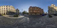 a 360 - view photo of a city street surrounded by old buildings and a car