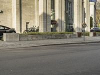 a person riding an on a motorcycle in a city street with buildings behind them, and trees in the background