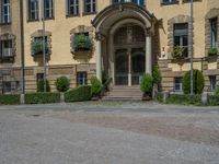 large yellow building with some plants and bushes in front of it for decoration or entertainment