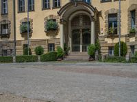 large yellow building with some plants and bushes in front of it for decoration or entertainment