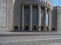 an entrance of a building with large columns and doors that spell out the word voltege