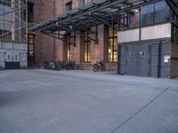 many bikes are parked outside an open building with brick walls and doors to each side