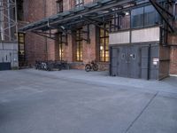 many bikes are parked outside an open building with brick walls and doors to each side