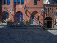 cobblestone driveway surrounded by modern buildings on sunny day with sun reflecting onto the windows