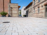 two brick buildings are built on a city street with cobblestone walkways that lead to the doors