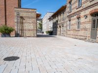 two brick buildings are built on a city street with cobblestone walkways that lead to the doors