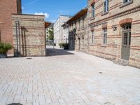 two brick buildings are built on a city street with cobblestone walkways that lead to the doors