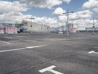 parking lot at an airport with sky in background and buildings in the distance behind the empty parking lot