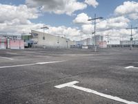 parking lot at an airport with sky in background and buildings in the distance behind the empty parking lot