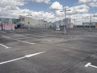 parking lot at an airport with sky in background and buildings in the distance behind the empty parking lot