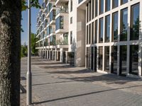 the building is surrounded by many glass panels in the courtyard, and has brick paving in the front