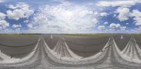 a tarmac next to the runway on a cloudy day as clouds are low overhead