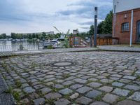 a paved patio sitting on top of a sidewalk next to a river bank in a city