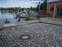 a paved patio sitting on top of a sidewalk next to a river bank in a city