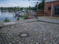 a paved patio sitting on top of a sidewalk next to a river bank in a city